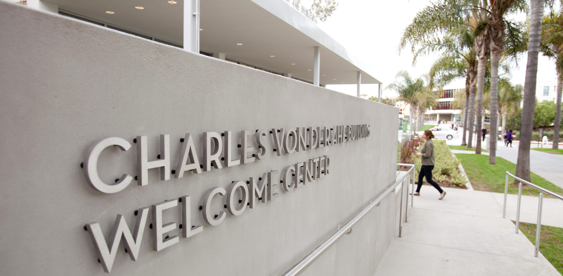 Welcome Center Sign; student walking